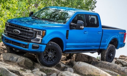 2020 Ford Super Duty performance blue powering over rocks forest