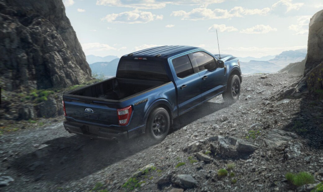 A Ford F-150 driving on a dirt road.