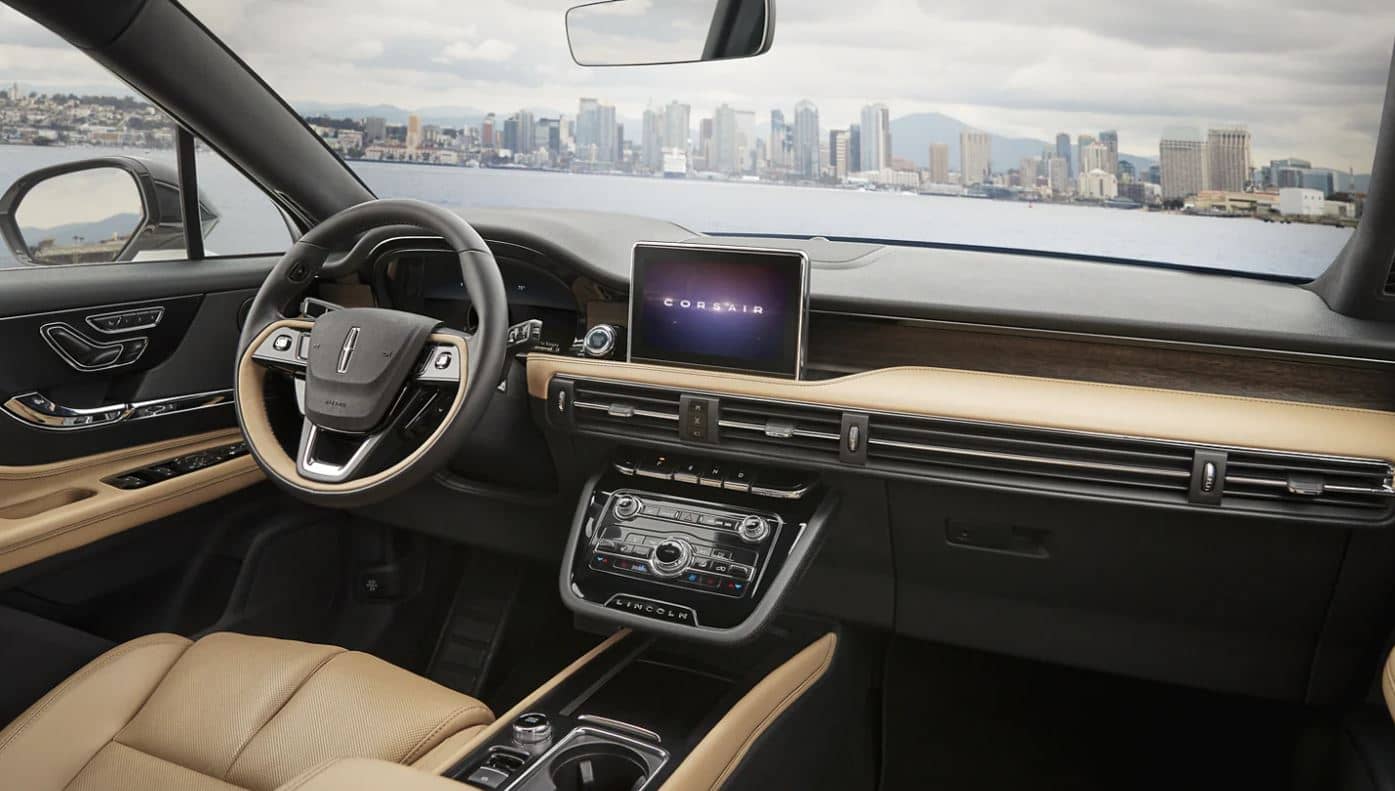 The interior and dashboard of the 2022 Lincoln Corsair SUV overlooking a lake with a city skyline on the other side