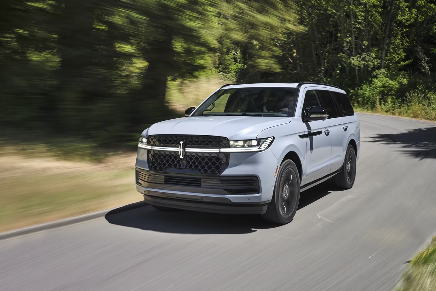 A 2025 Navigator driving down a road.