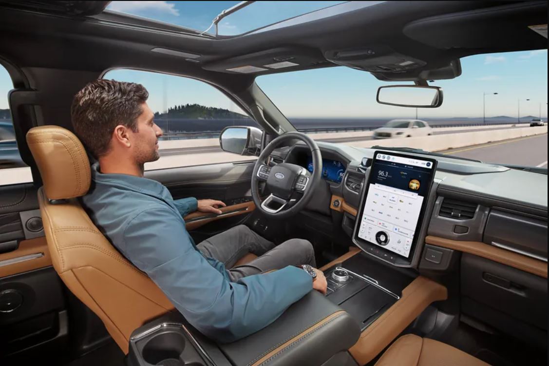 A man sitting in a new Ford using the hands free BlueCruise feature.