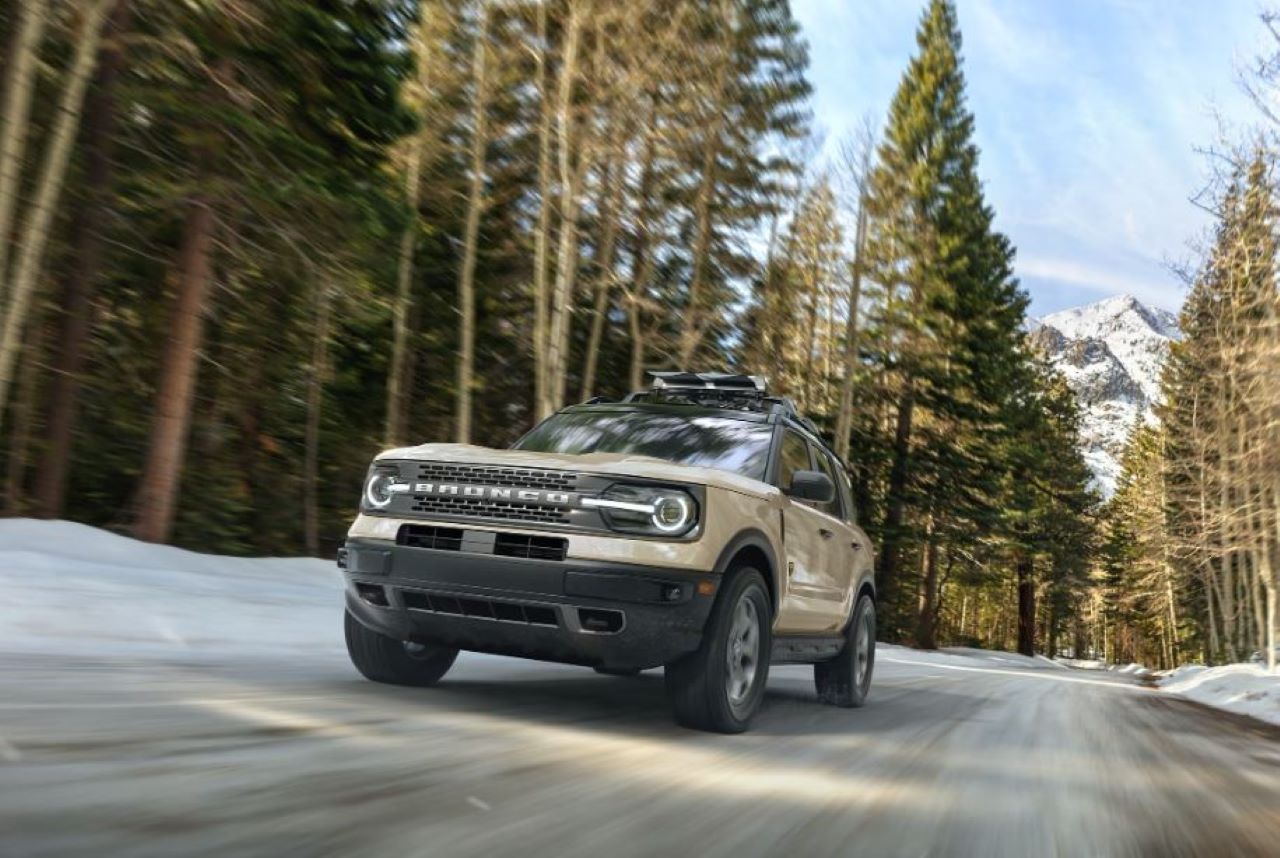 A Ford Bronco Sport driving up a snowy mountain road.