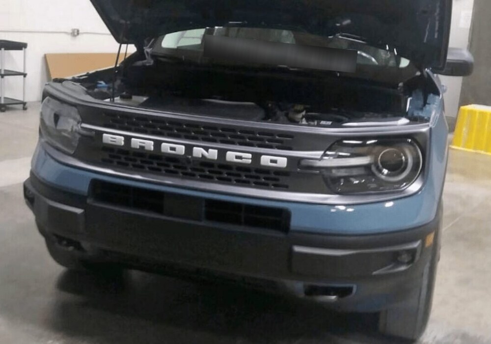 Front exterior grille view of a 2021 Ford Bronco Sport with the hood raised