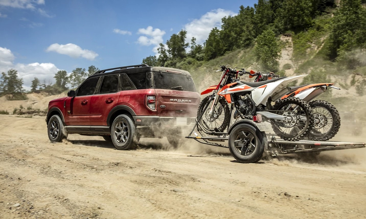 Red Ford Bronco Sport towing several 4x4 buggies