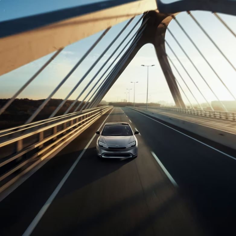A Toyota driving across a modern bridge.
