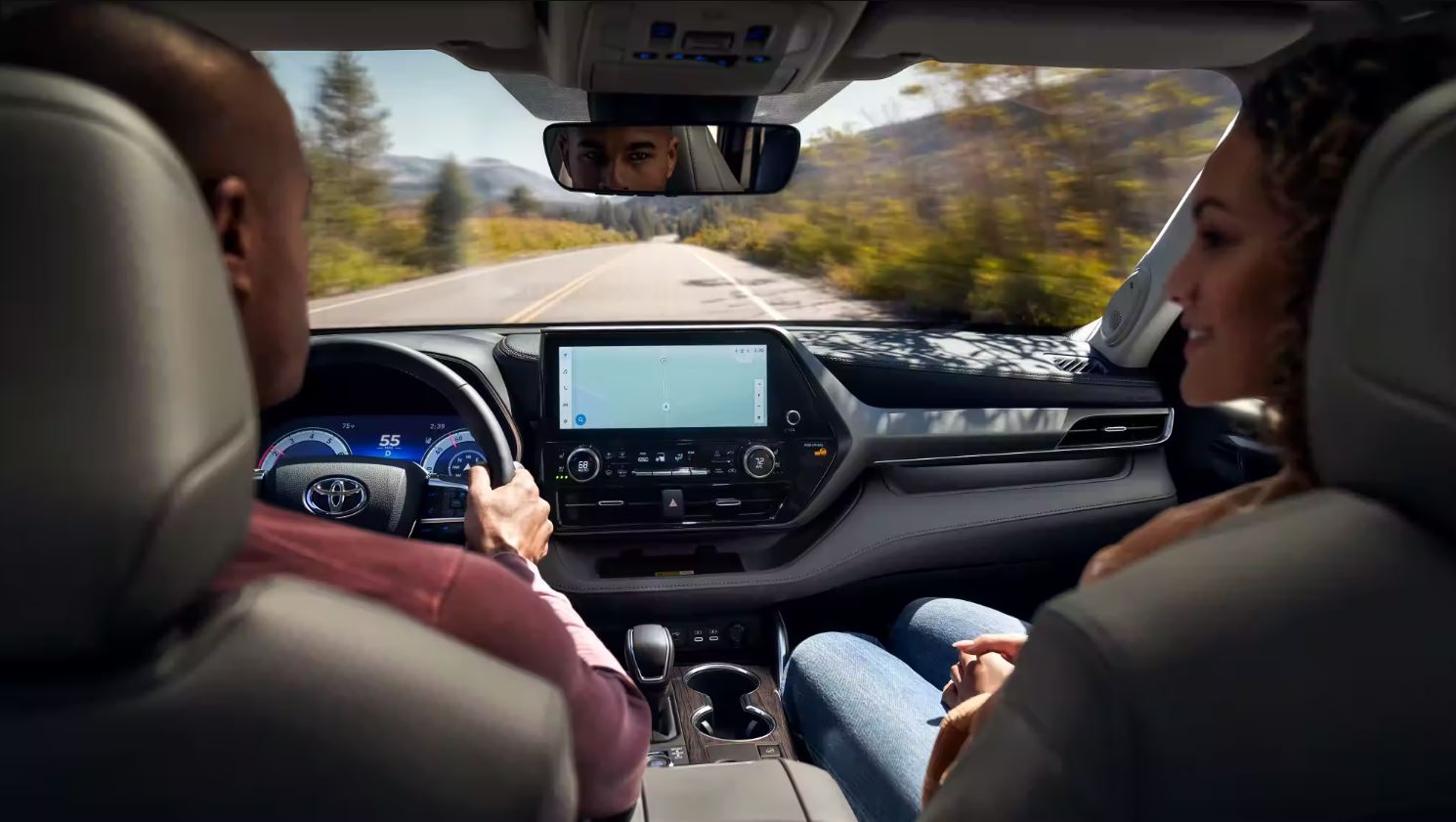 A person looking at some of the safty features inside of a new Toyota while driving.