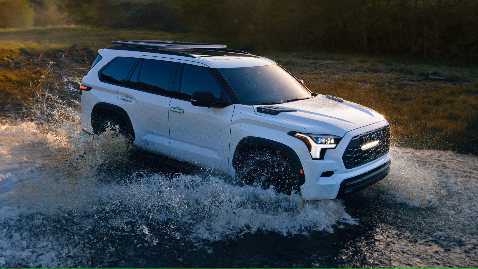 White 2025 Toyota Sequoia driving through a creek.