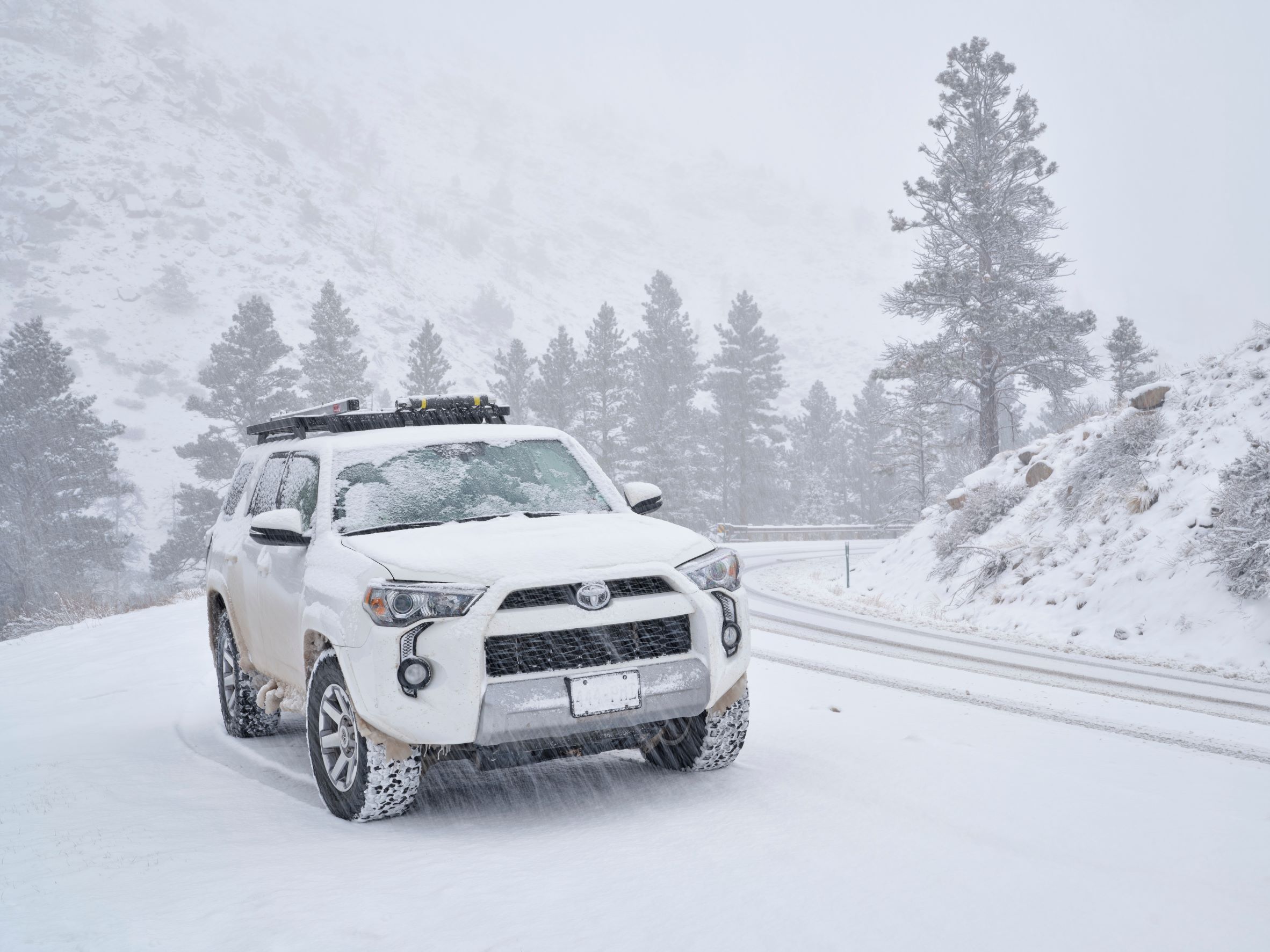 A Toyota 4 Runner driving through heavy snow.