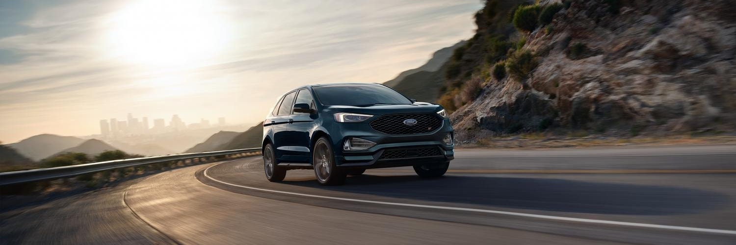 Blue Ford Edge driving up a mountain road