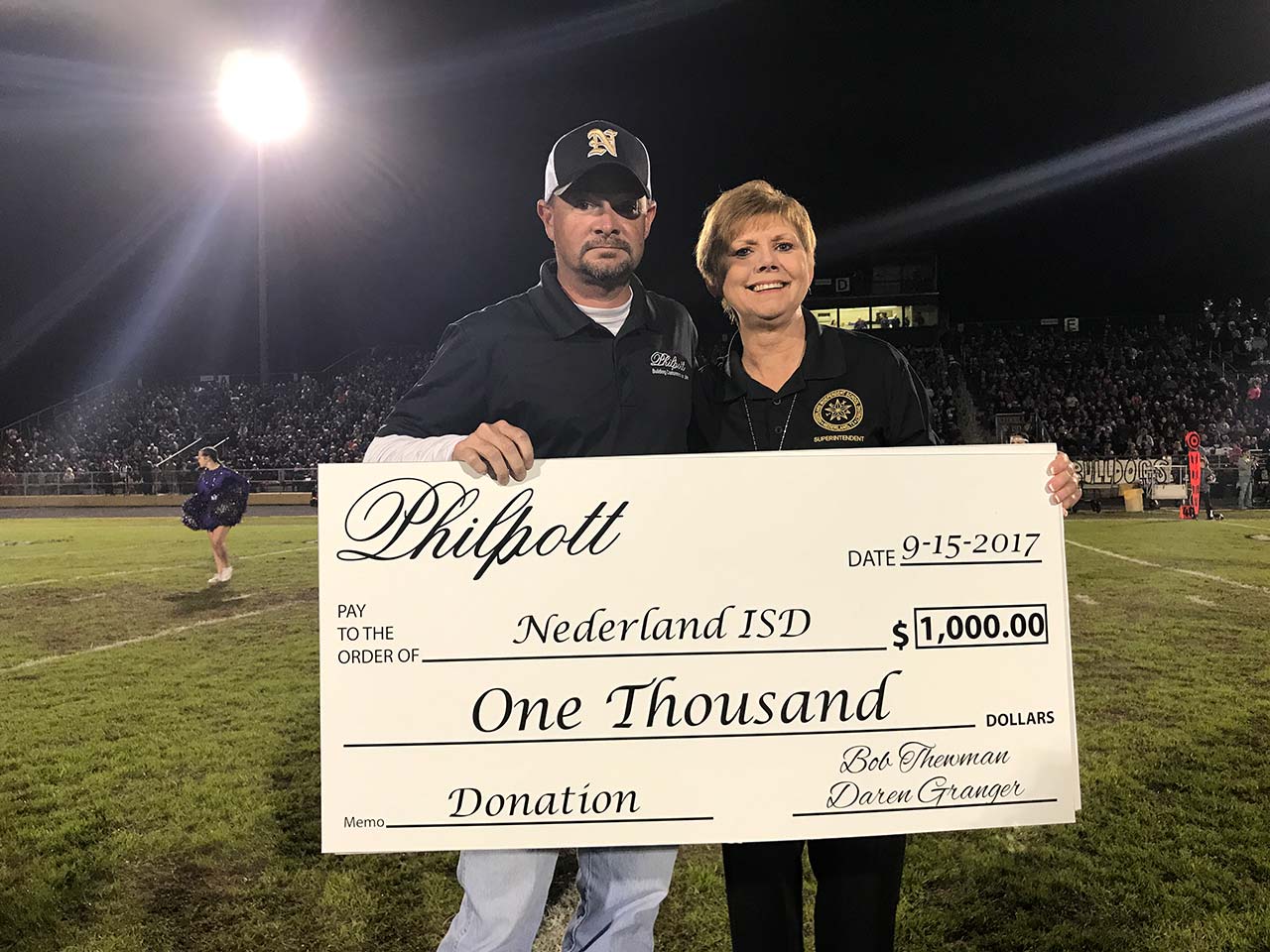 Philpott presents a check to Nederland ISD