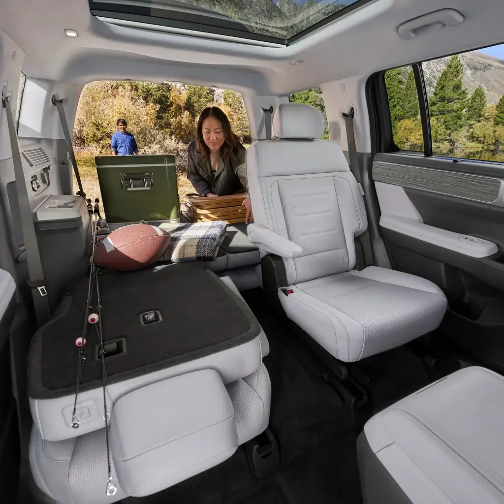 Hyundai Santa Fe Hybrid rear seats folding flat to expand the cargo floor, viewed from behind the driver seat