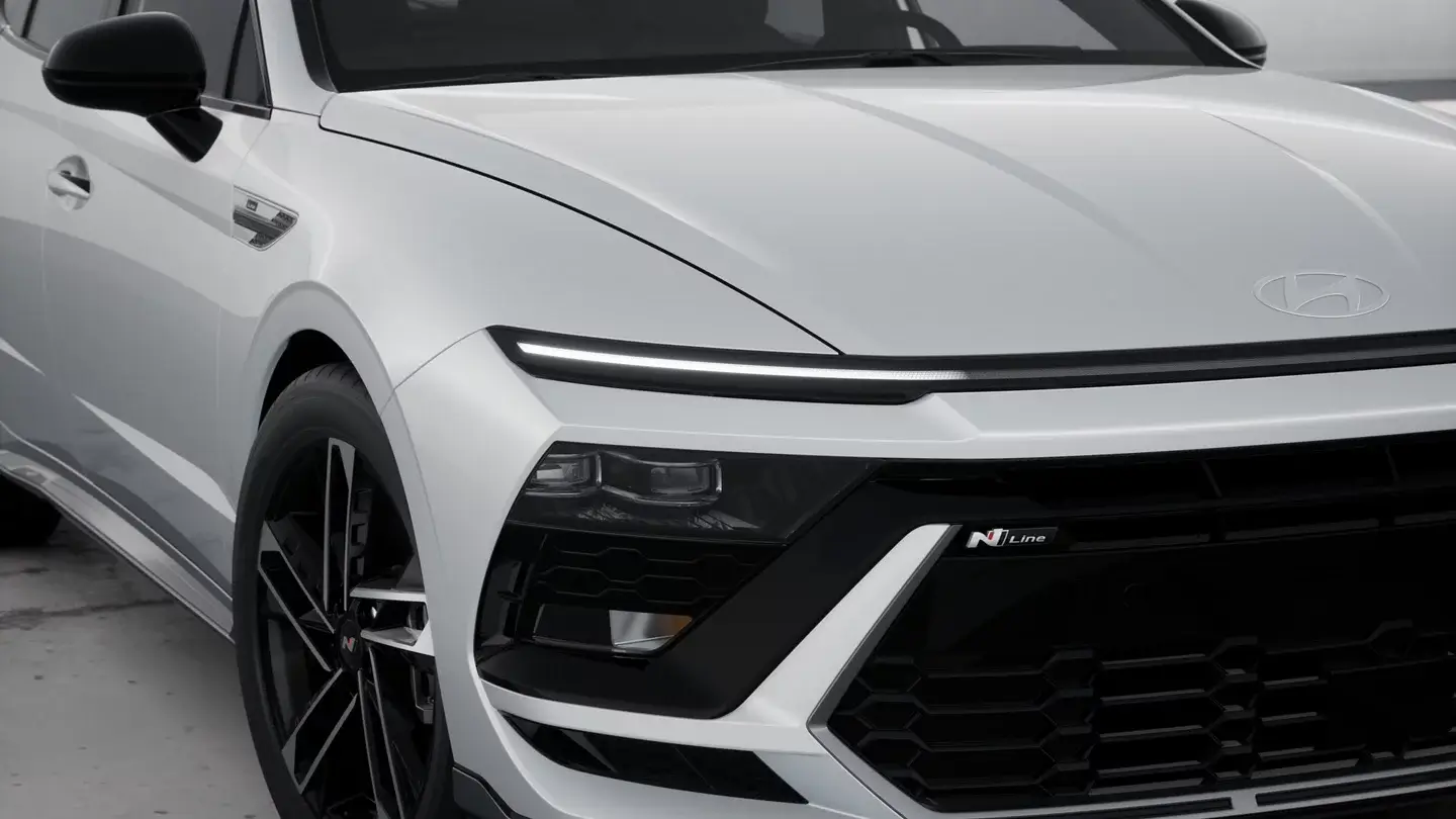 White Hyundai Sonata N Line front bumper with N Line badge and 19-inch wheel, close-up