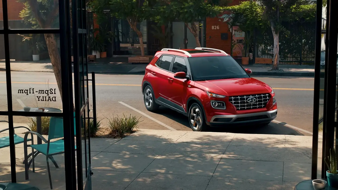 Hyundai Venue in Ultimate Red, front three-quarter view showing grille and headlights