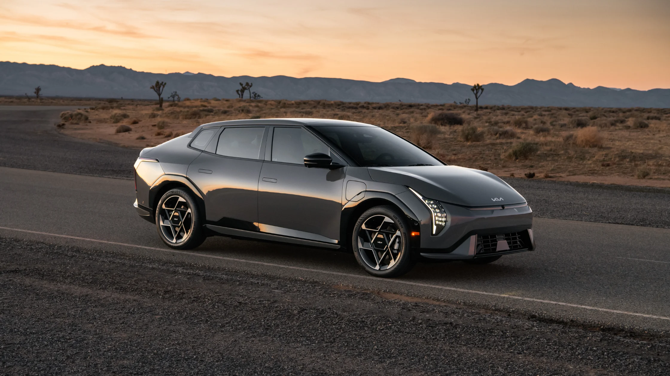 2026 Kia EV4 electric crossover parked on desert road at dusk showing sleek aerodynamic profile