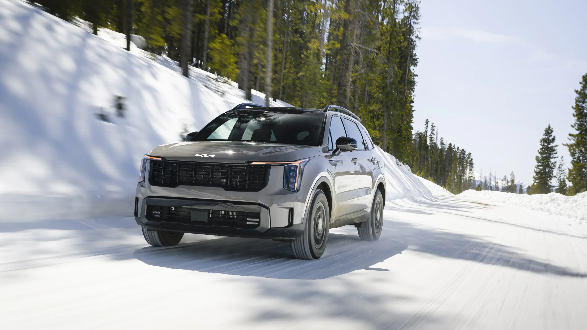 2026 Kia Sorento driving on snowy mountain road with rugged SUV stance and bold front