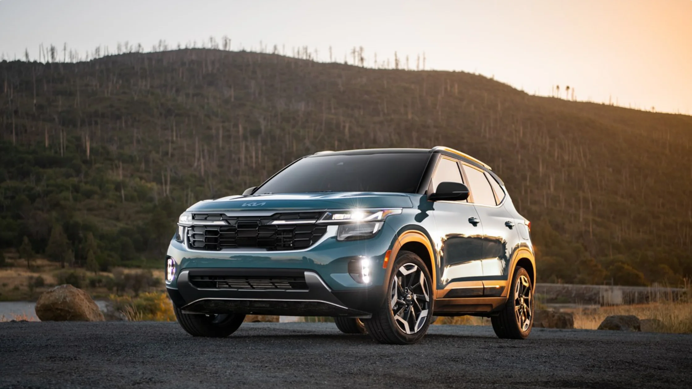 2026 Kia Seltos compact SUV parked outdoors with LED headlights and rugged mountain backdrop