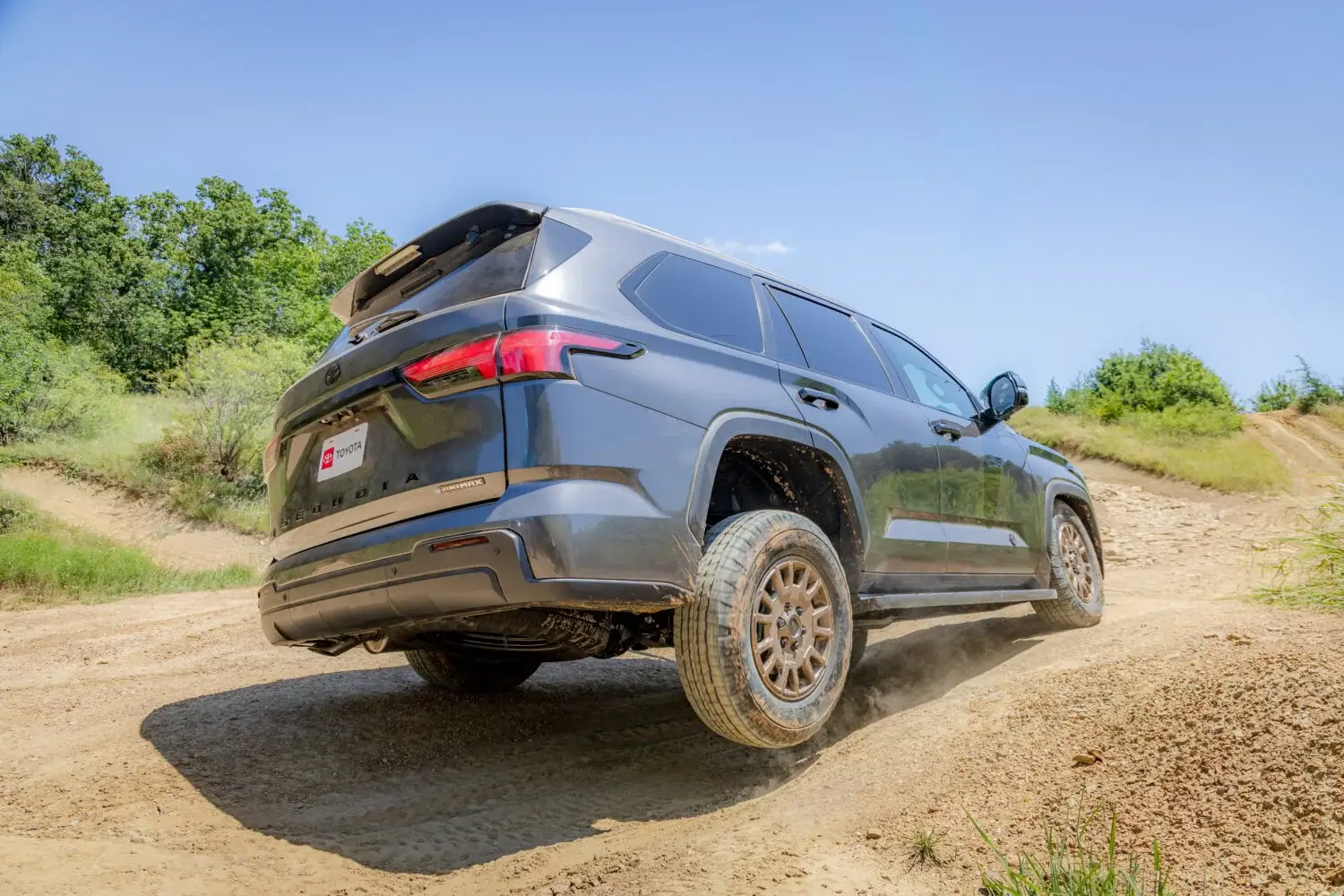 2027 Toyota Sequoia Trailhunter shown from the rear three-quarter angle off-road