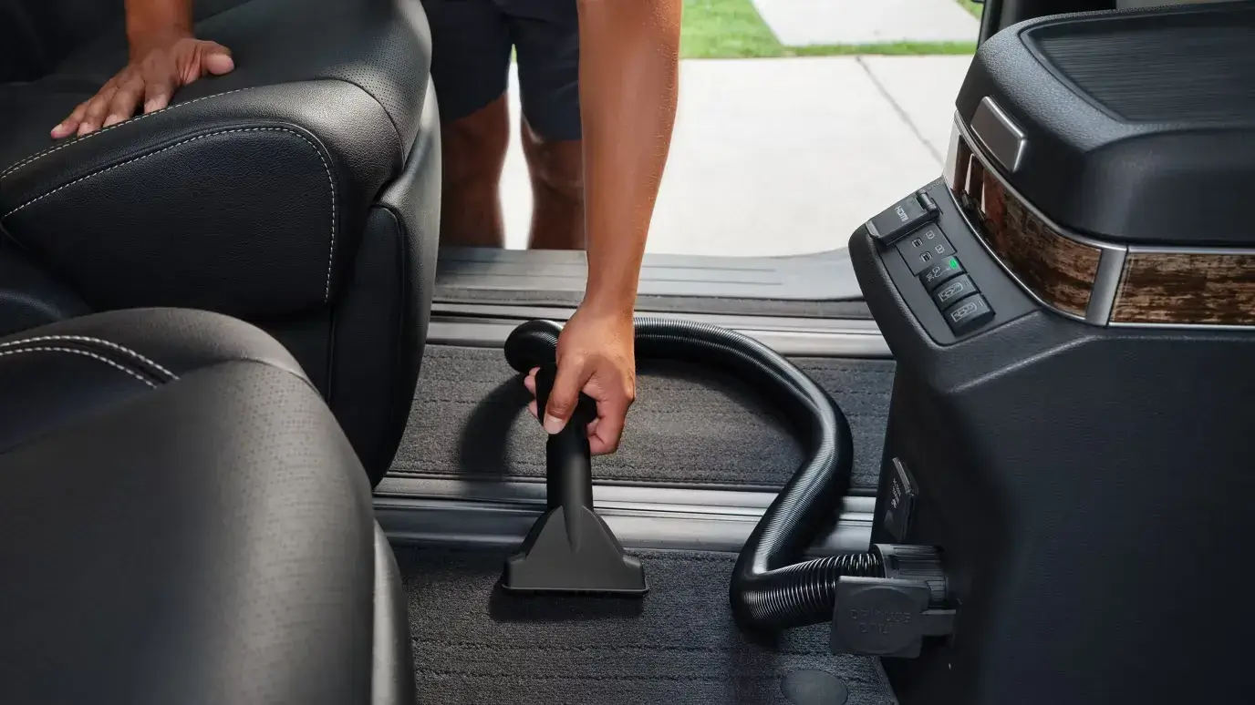Built-in vacuum cleaner in the Toyota Sienna being used to clean the cabin