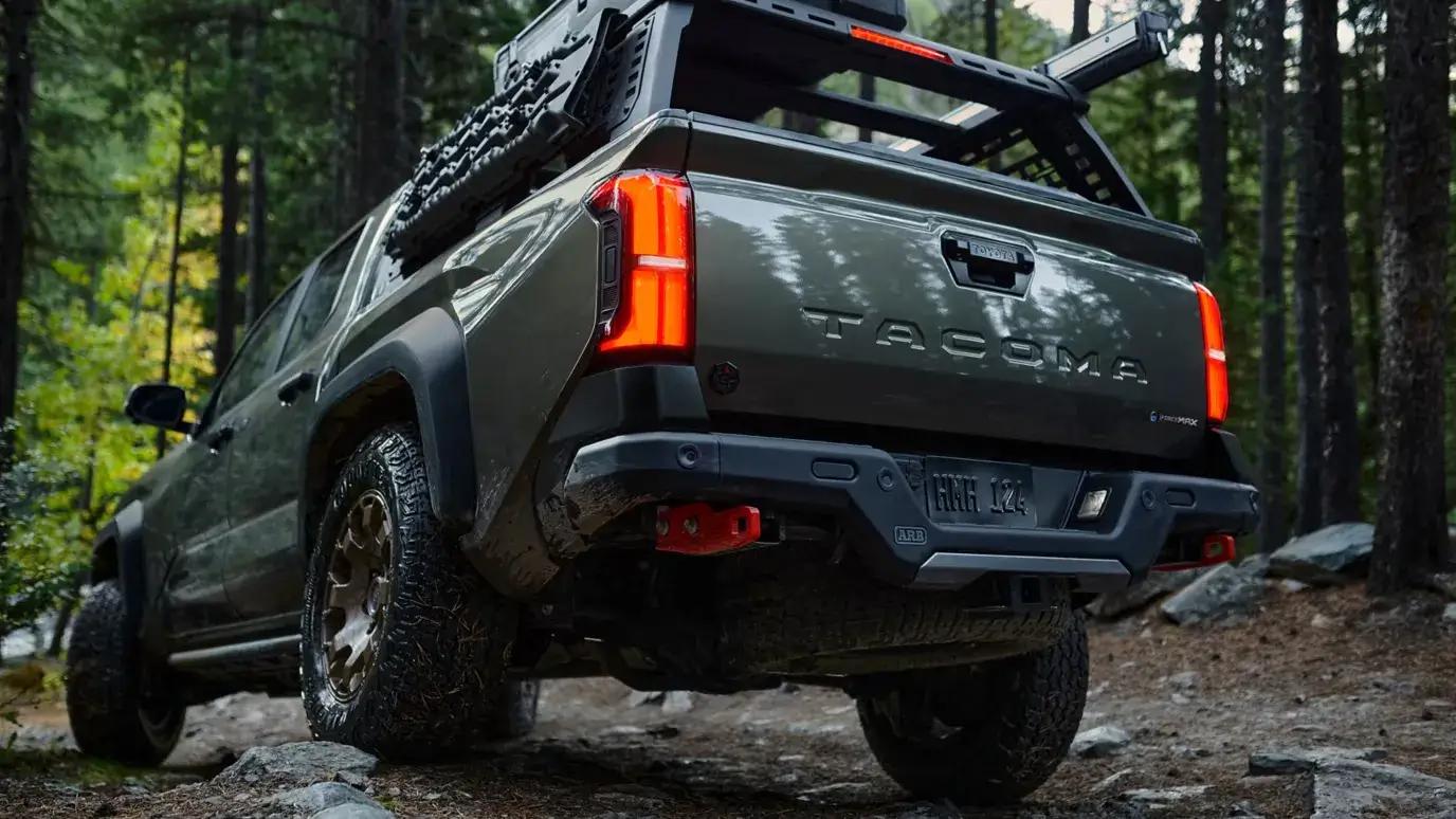 Toyota Tacoma i-FORCE MAX tail lights and rear bumper on an off-road trail