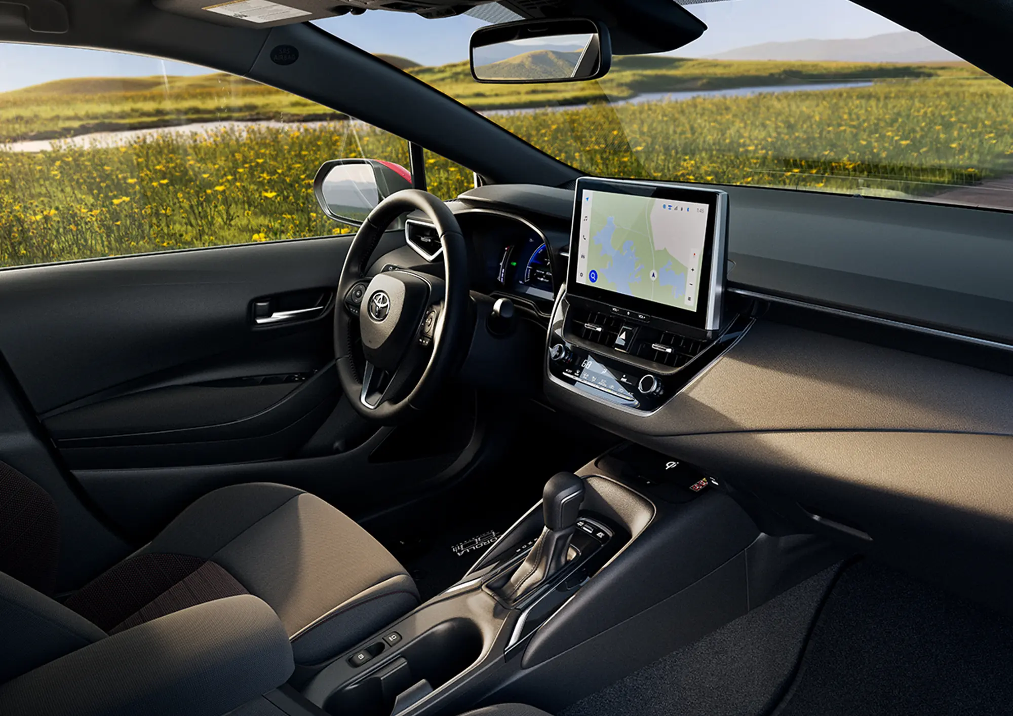 Toyota Corolla dashboard with the touchscreen and steering wheel, seen through the open door