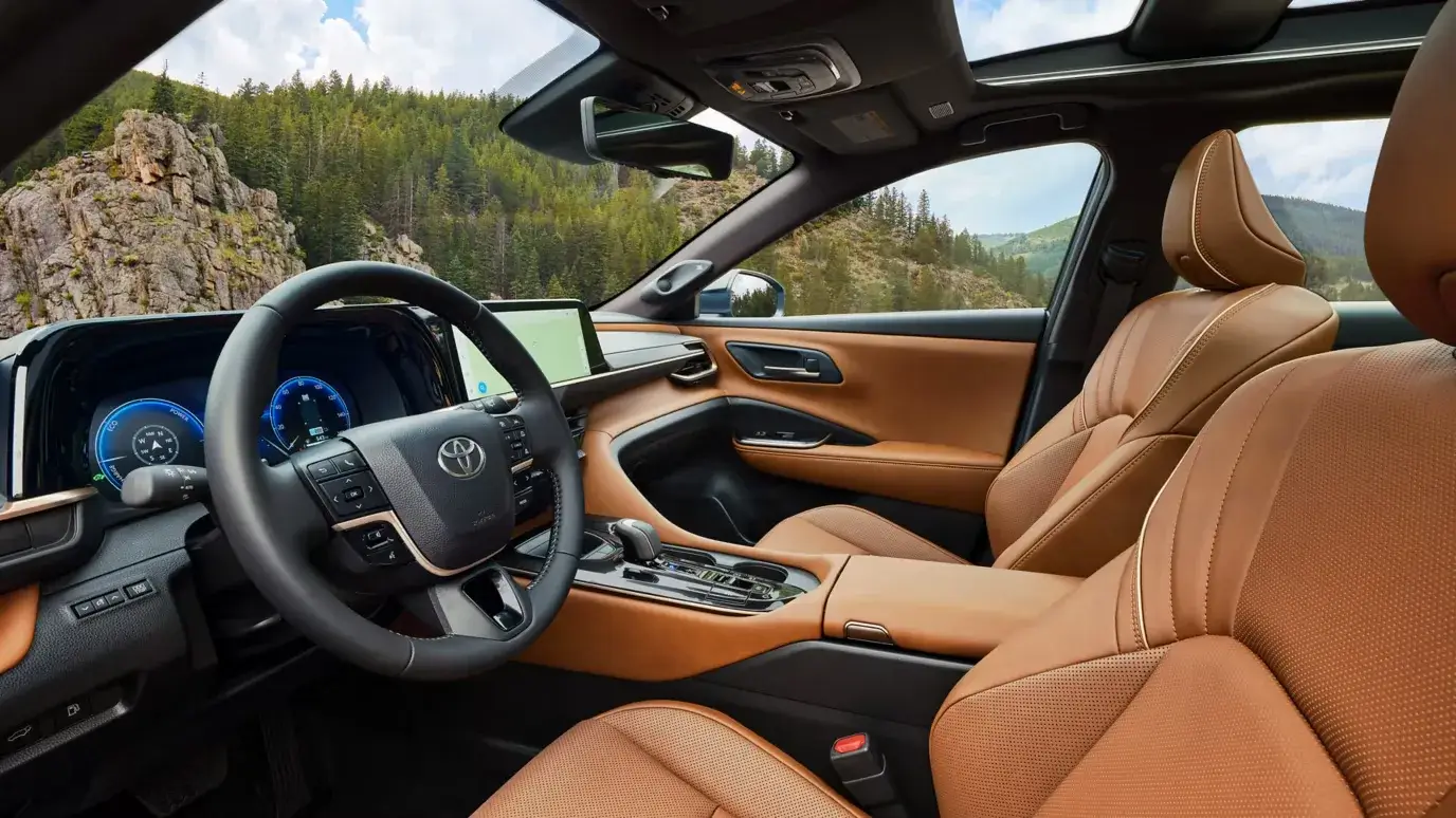 Saddle tan leather-trimmed interior of the Toyota Crown Signia viewed through the open driver door