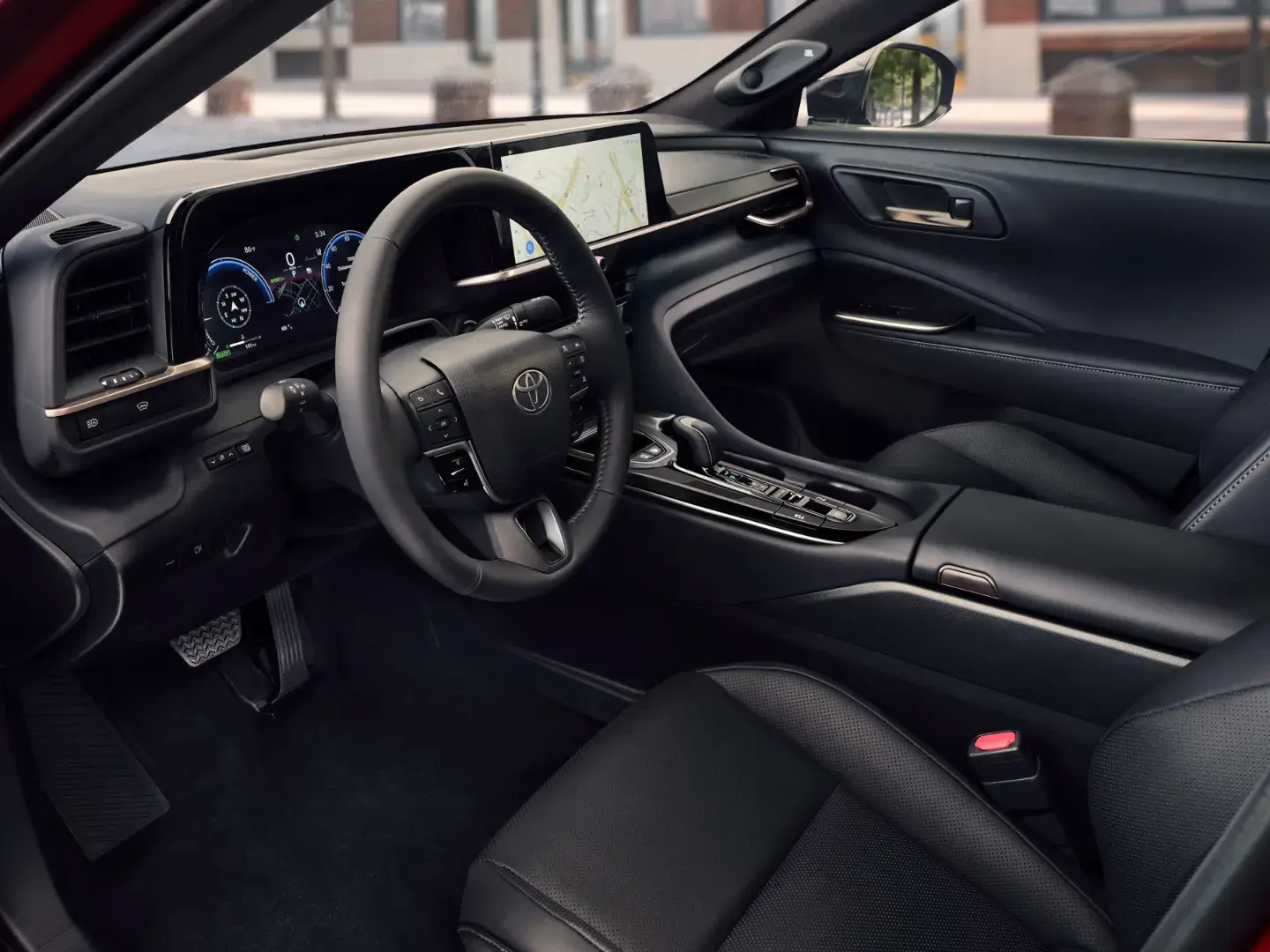 Interior of the 2027 Toyota Crown viewed through the open driver's door showing the tiered dashboard and leather-trimmed seats