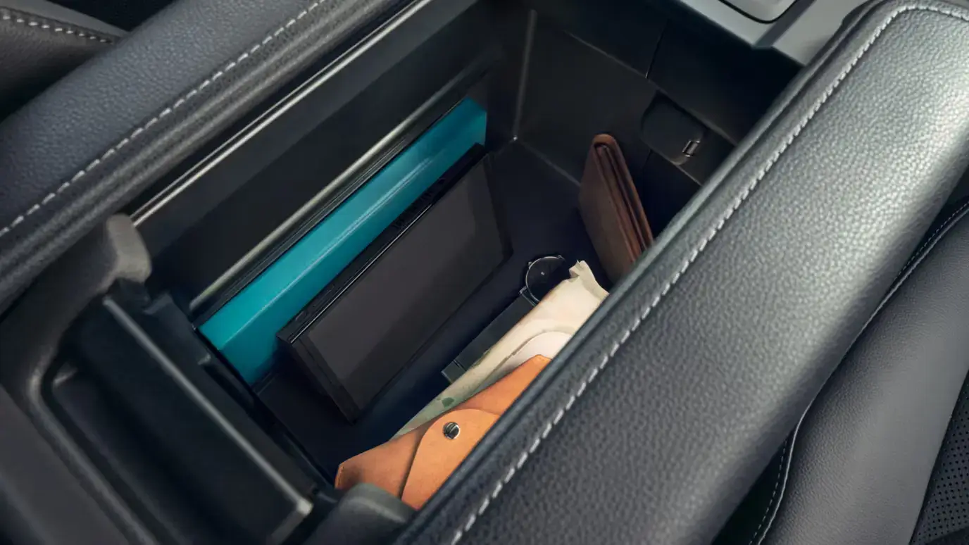 Grand Highlander Platinum Hybrid MAX interior in black leather with Ultrasuede trim showing the center armrest storage compartment