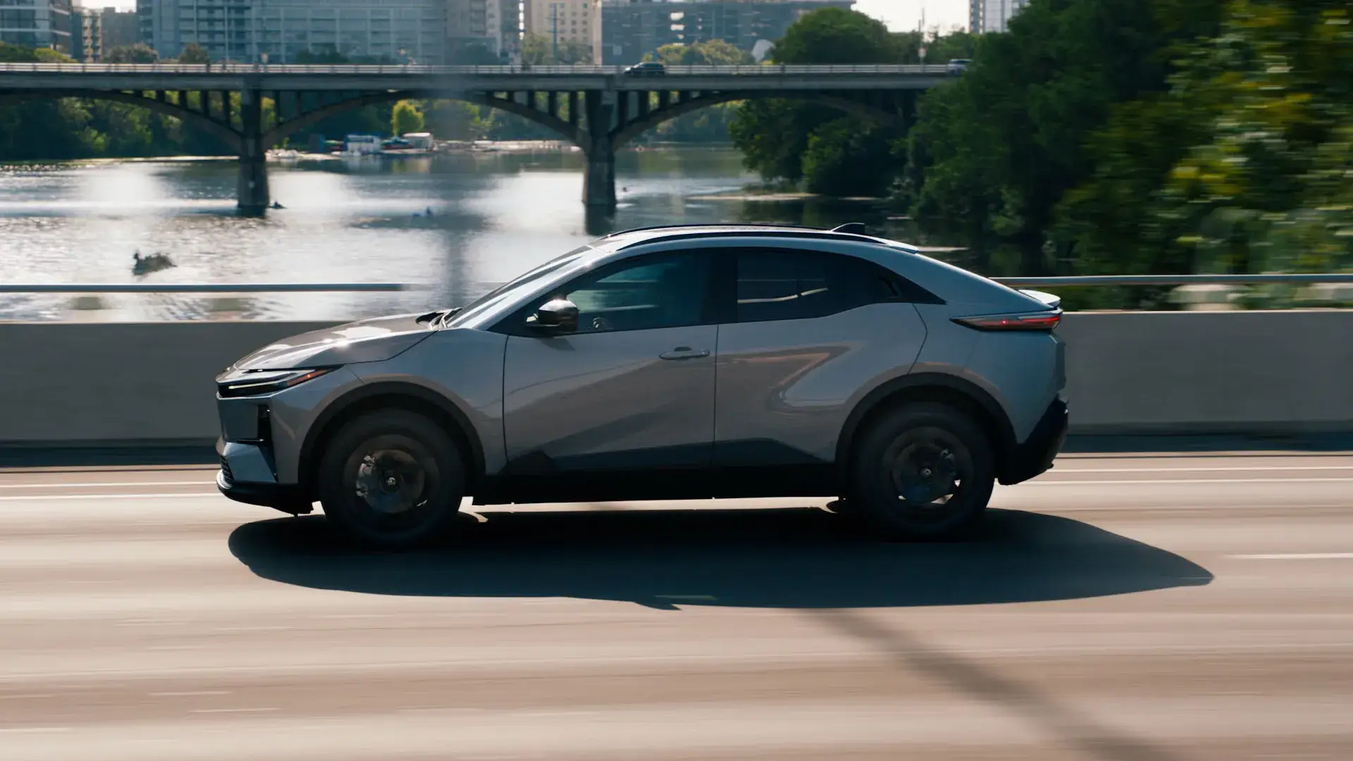 Toyota C-HR electric SUV driver side view showing 18-inch wheels and low-profile roof rails