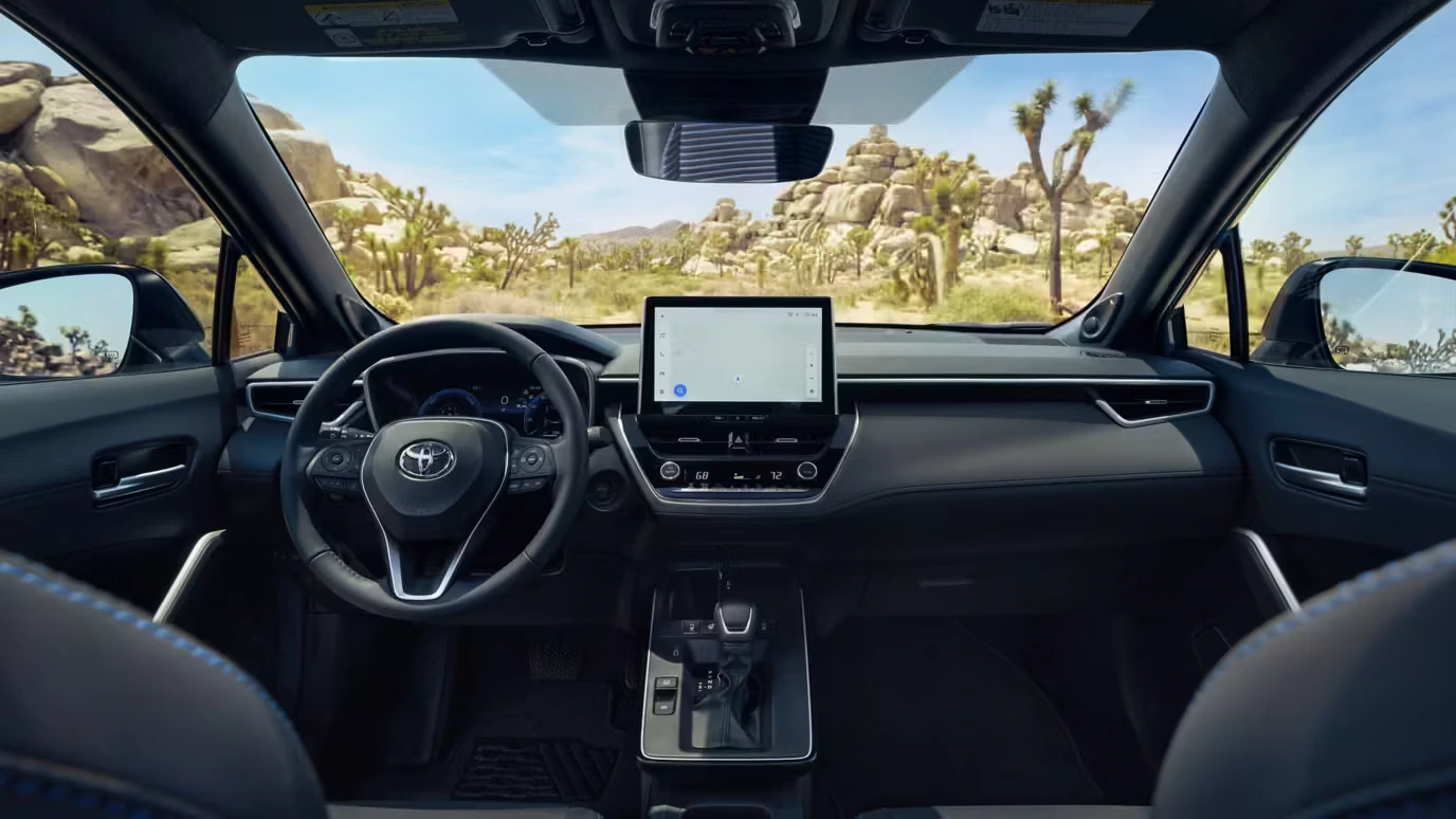 View from the back seat of a Corolla Cross Hybrid XSE toward the steering wheel, shifter and screens