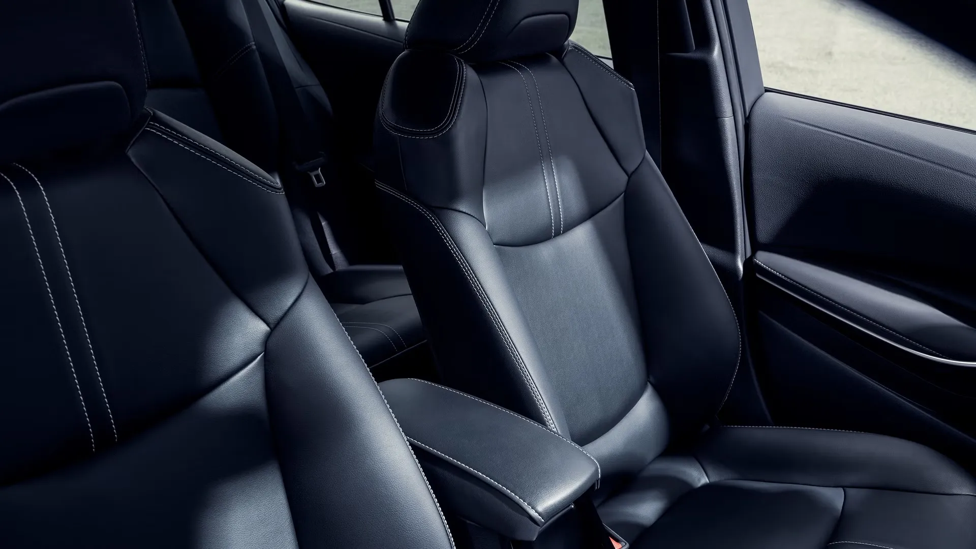 Toyota Corolla Hybrid XLE interior shown in black SofTex trim with digital gauge cluster