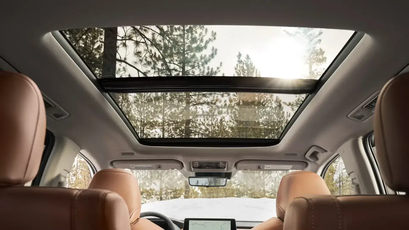 Toyota Grand Highlander panoramic moonroof seen from the second row, with brown leather seats