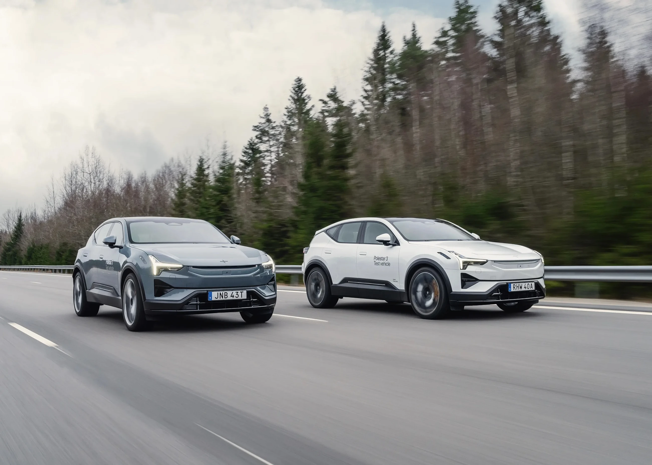 Two Polestar 3 driving down a quiet highway side by side