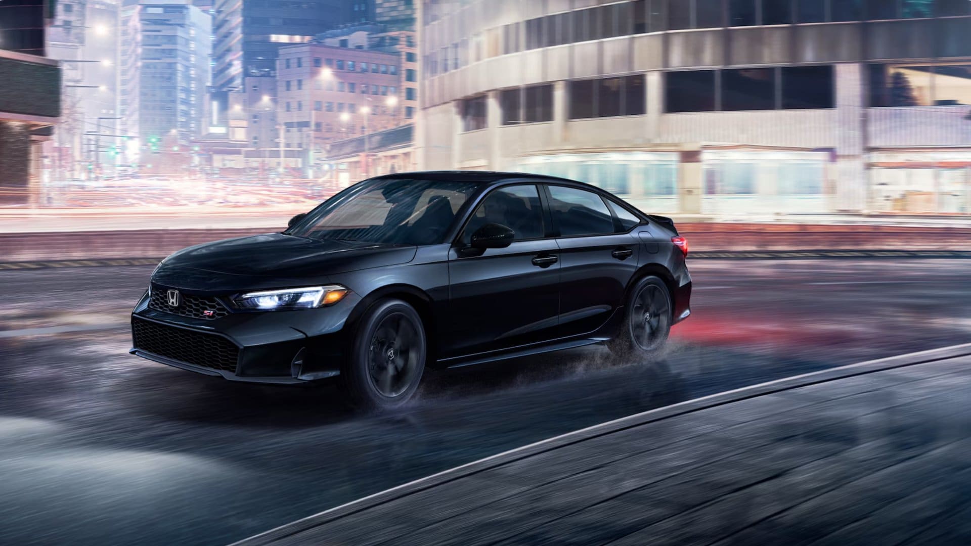 Black 2026 Honda Civic Si driving on a wet city street at night with motion blur