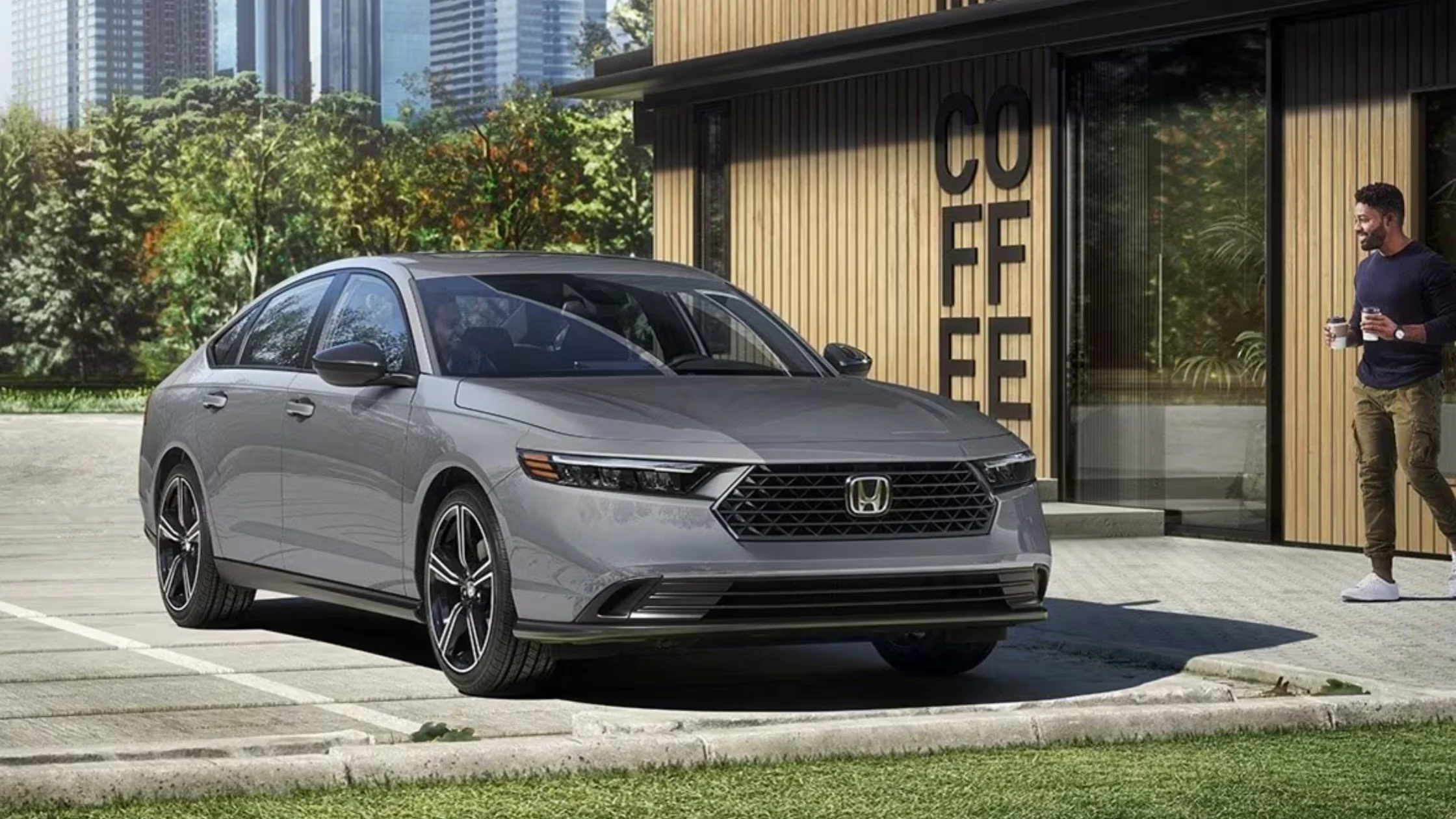 2026 Honda Accord sedan in gray parked near a coffee shop, emphasizing refined exterior design and LED headlights.