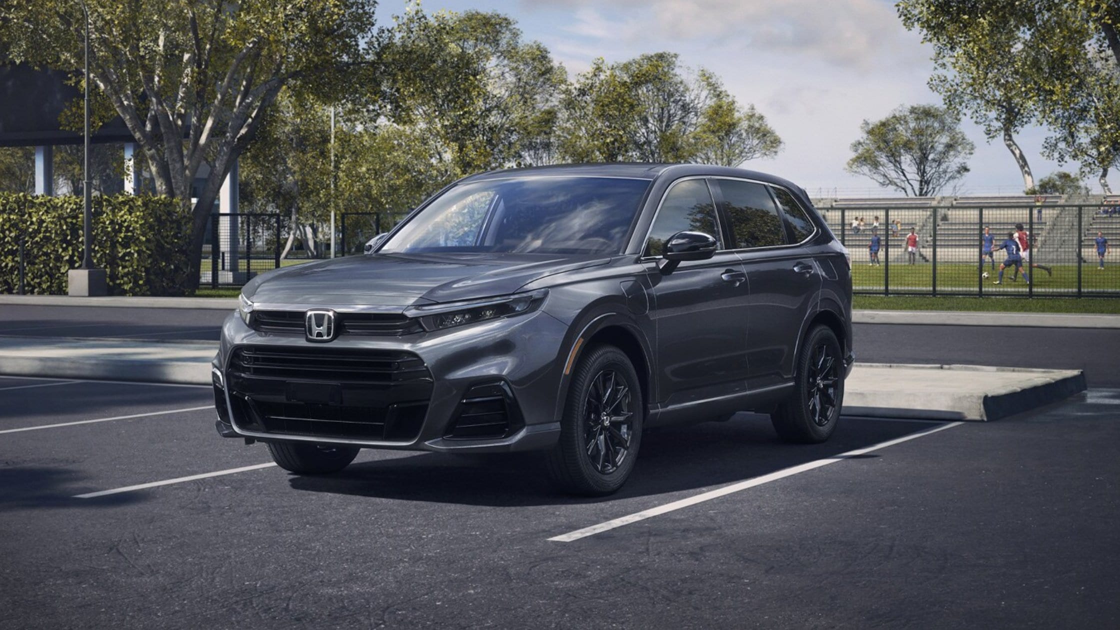 2026 Honda CR-V e:FCEV in gray parked near a sports field, showing its front three-quarter exterior.