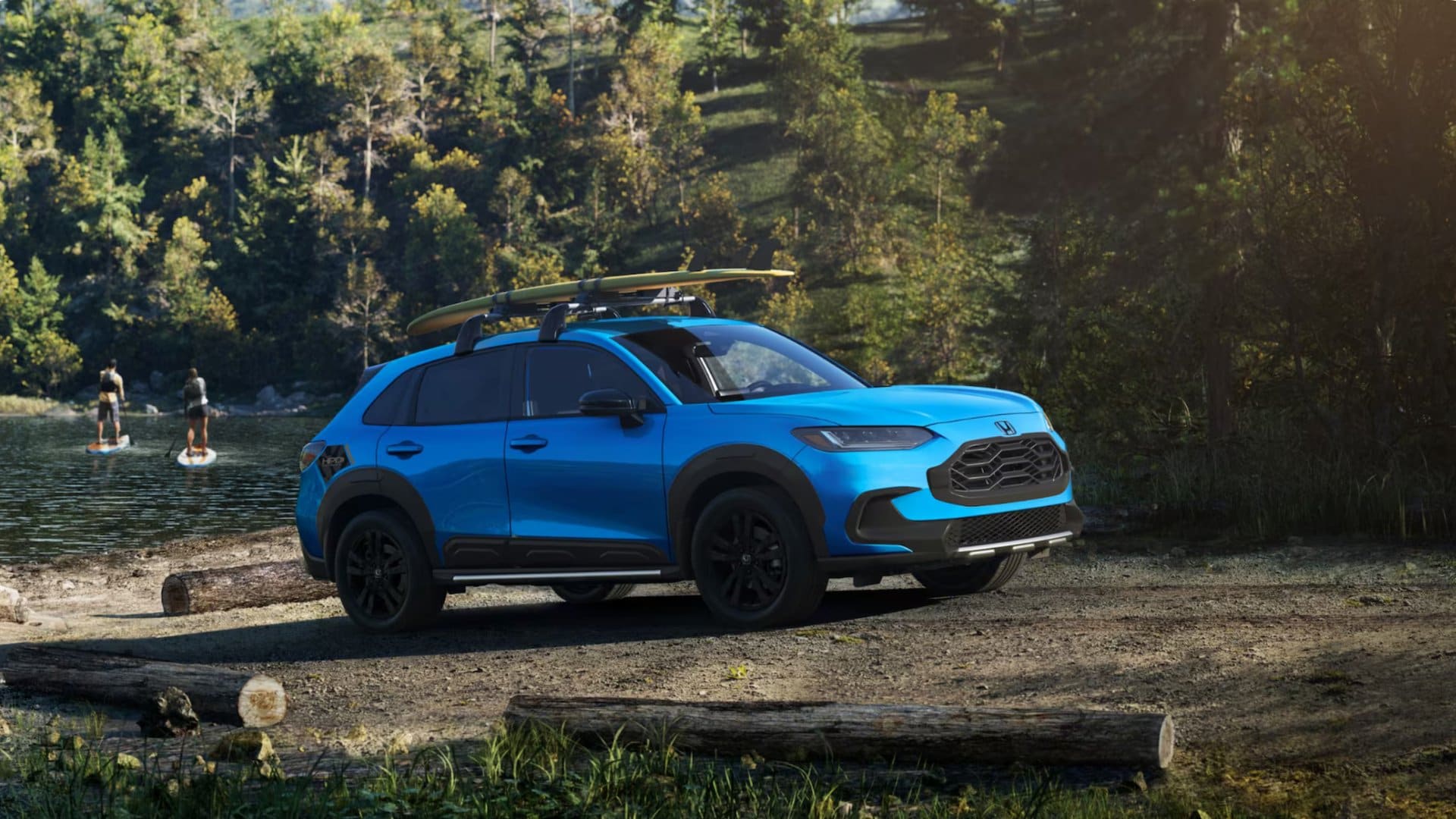 Blue 2026 Honda HR-V parked by a lakeside campsite with paddleboards on the roof