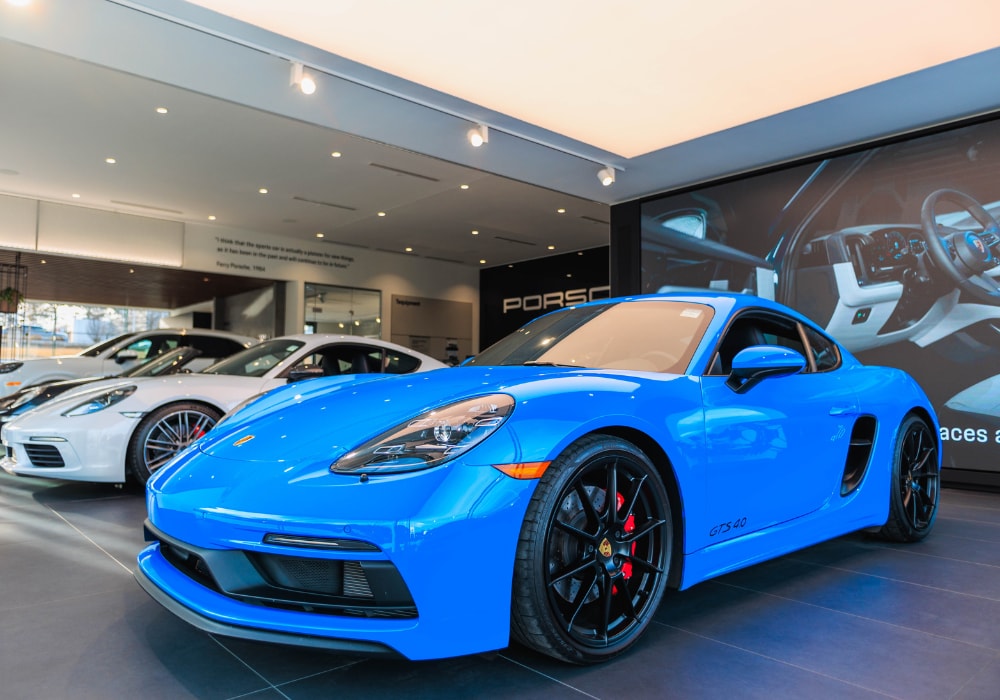 Bright blue Porsche car for sale parked inside the showroom of Porsche Asheville