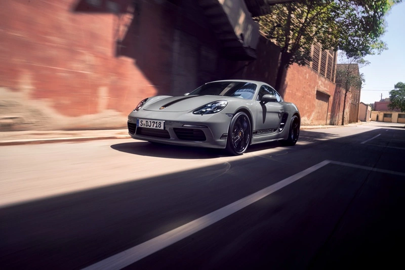 Grey Porsche 718 Cayman driving down street