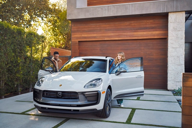 White Porsche Macan parked in driveway with two people getting in