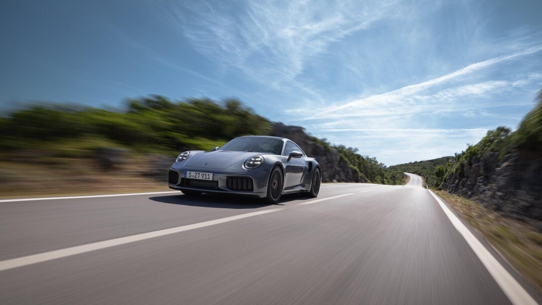 Silver Porsche 911 Driving Down a Road