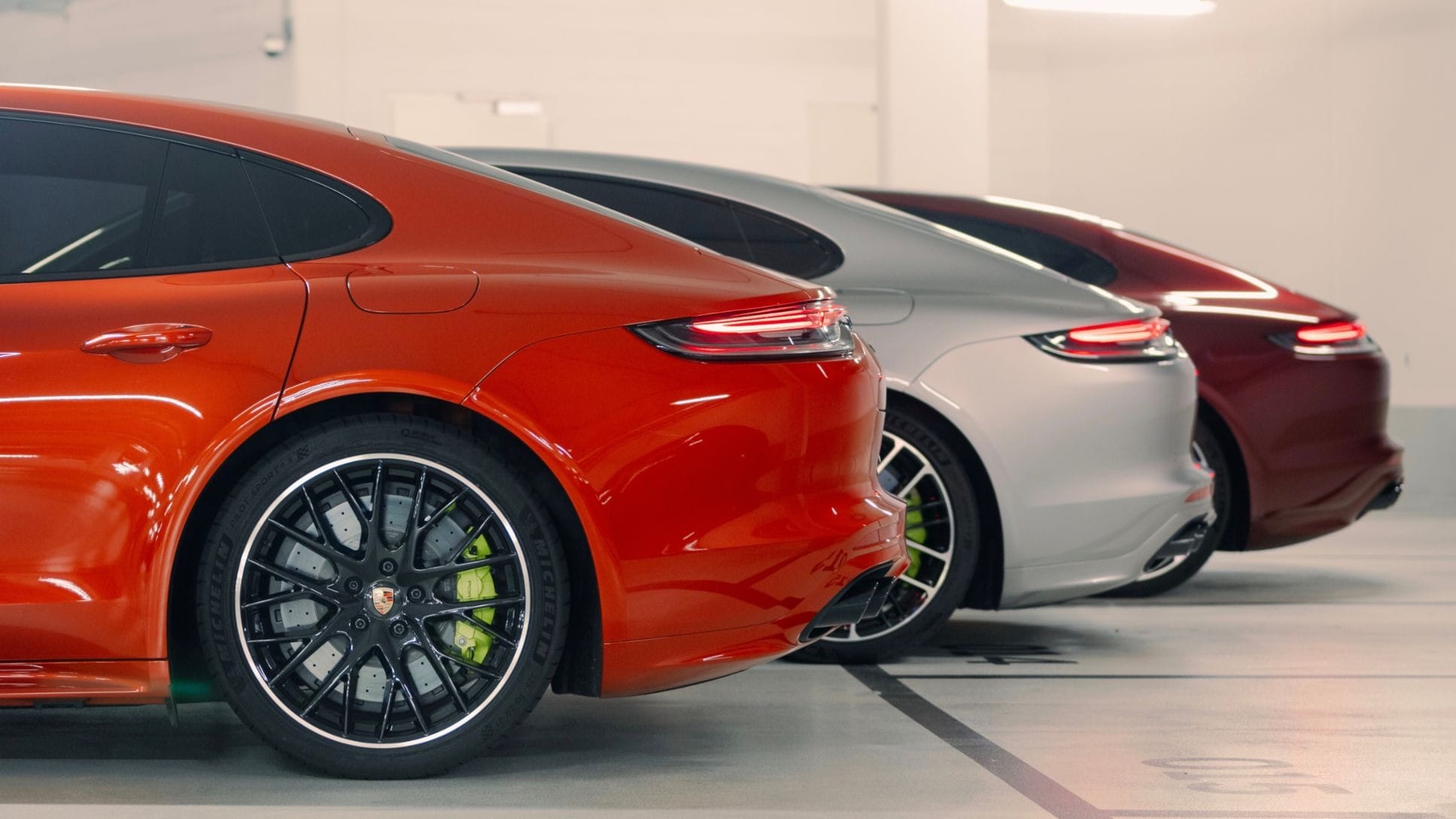 Three Porsche models parked in a garage