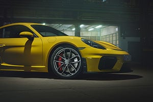 Porsche 718 Cayman Yellow Porsche Cayman parked inside a warehouse