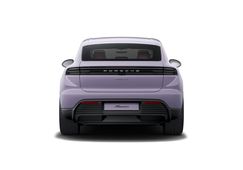 Exterior rear view of a 2025 Porsche Macan Electric. The luxury SUV is purple and in front of a white background