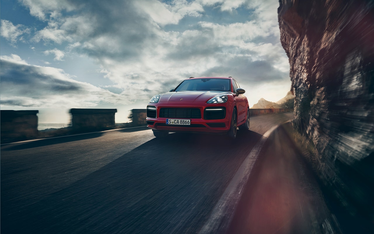 red Porsche Cayenne coming fast around a corner