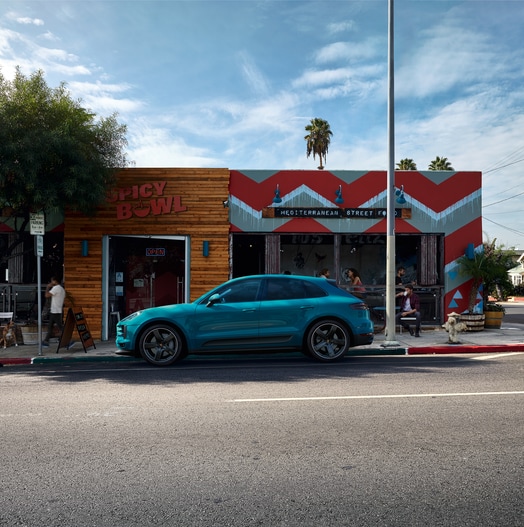 turquoise blue Porsche Macan parked in front of a Southern California restaurant