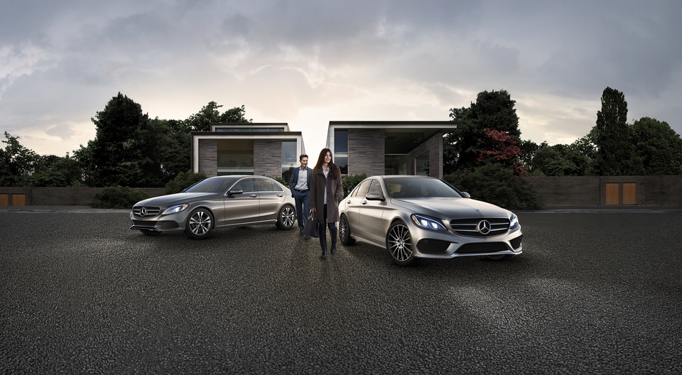 two Mercedes-Benz cars parked in a wide, long, gravel driveway