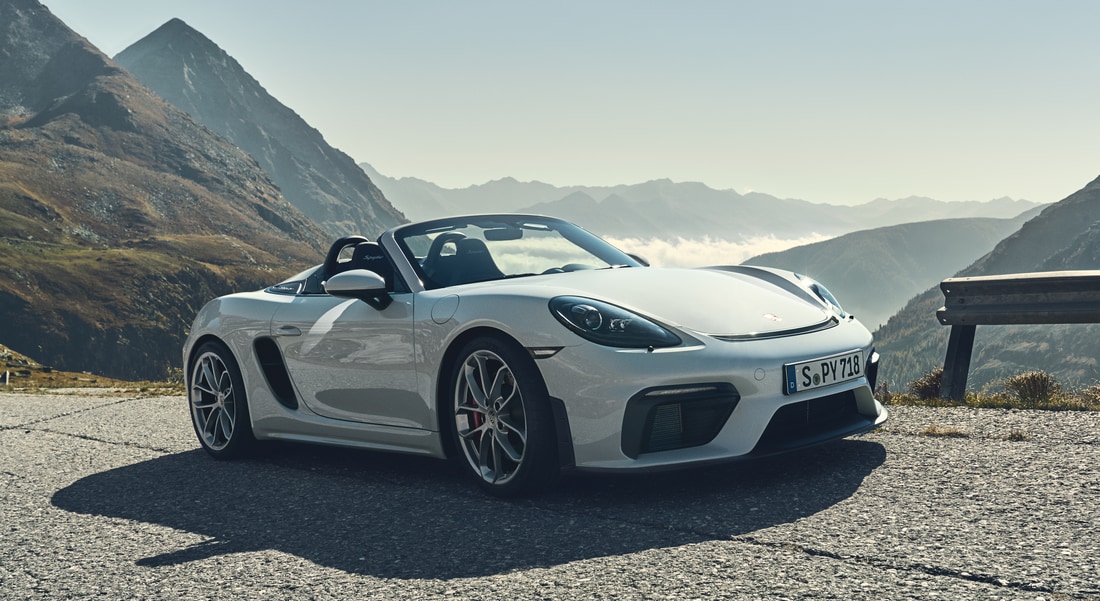 2024-Porsche-718-Spyder-Convertible-L01.png white Porsche 718 parked on a ridge in the mountains