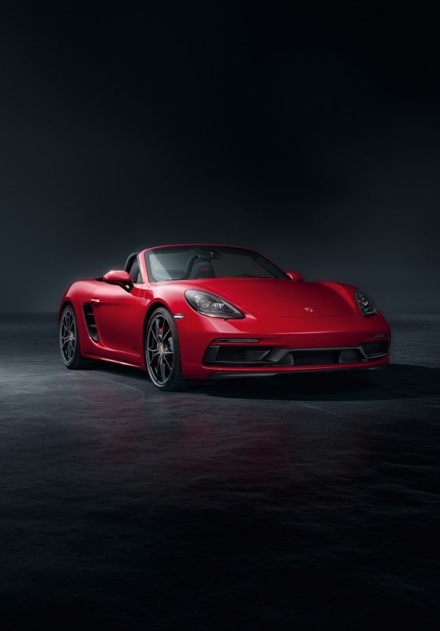 white Porsche 718 parked on a ridge in the mountains