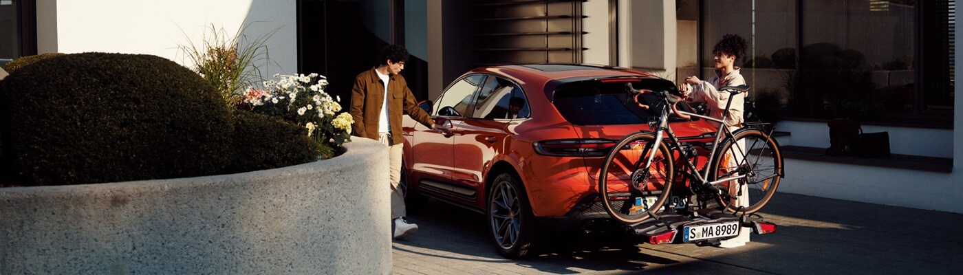 Orange Porsche Macan having bikes loading on the back