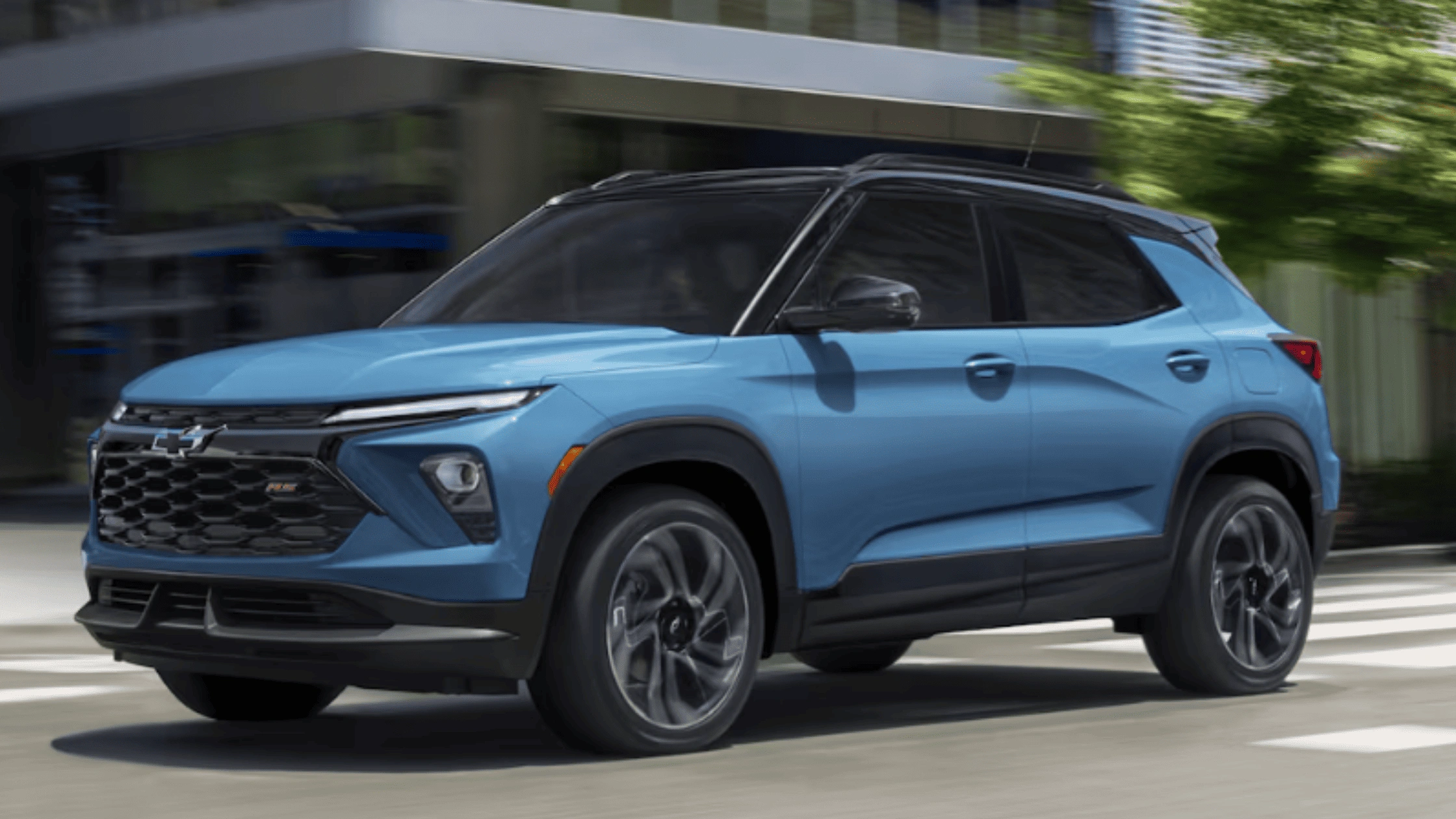 2026 Chevrolet Trailblazer in blue driving through the city, showcasing compact SUV safety and performance near Fort Bragg, NC.